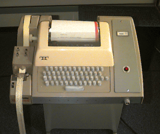 a teletype with typewriter keyboard and roll of
        paper