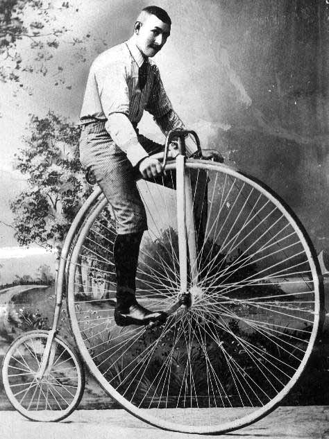 man riding a high wheeled bicycle