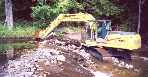 backhoe removing small dam