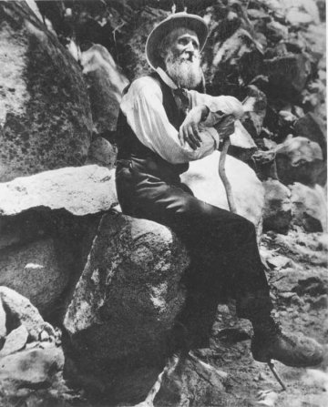 John Muir sitting on a rock